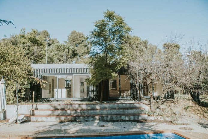 Casa moderna rodeada de árboles junto a piscina